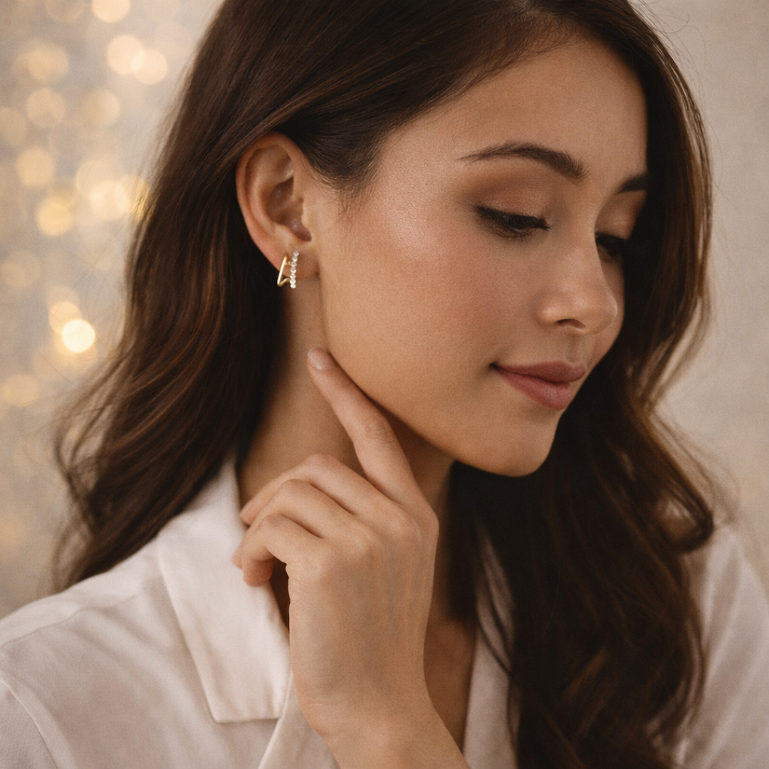 Close-up of minimalist gold hoop earrings with diamonds worn by a model.